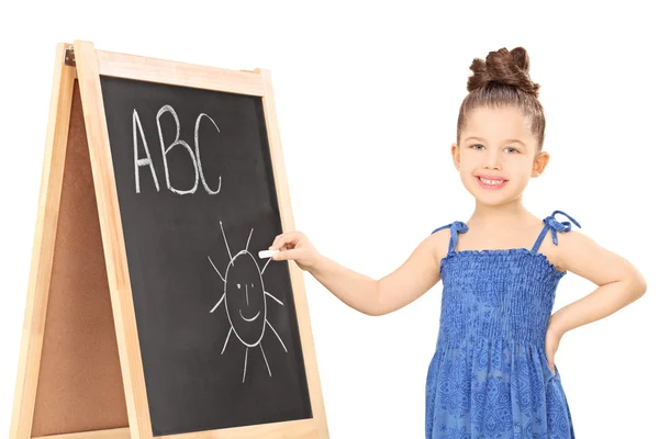 Girl writing on blackboard with chalk — Stock Photo, Image