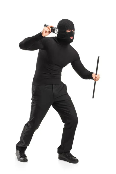 Robber with mask holding a flashlight — Stock Photo, Image