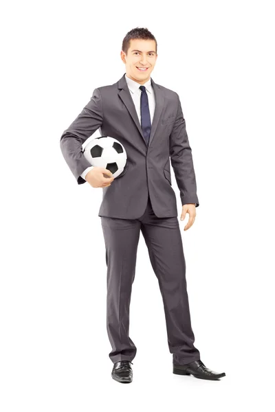 Homme d'affaires tenant le football — Photo