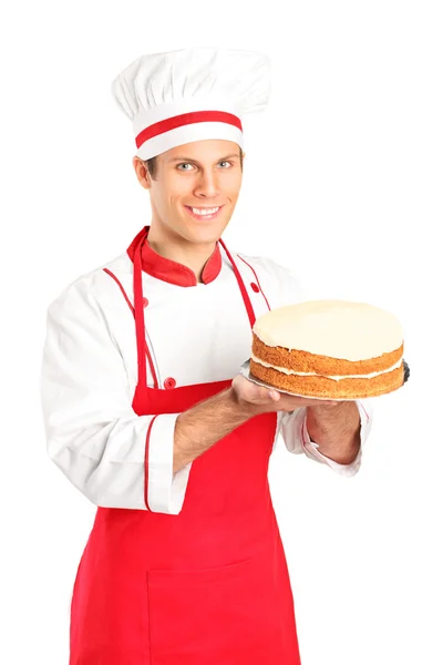 白い背景で隔離ケーキ保有笑顔若いシェフ — ストック写真