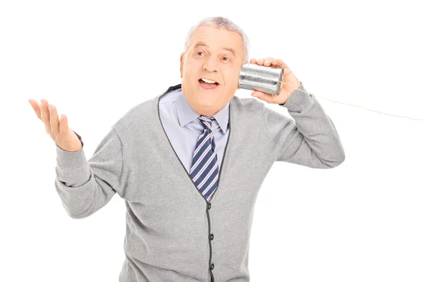 Senior talking through a tin can phone — Stock Photo, Image