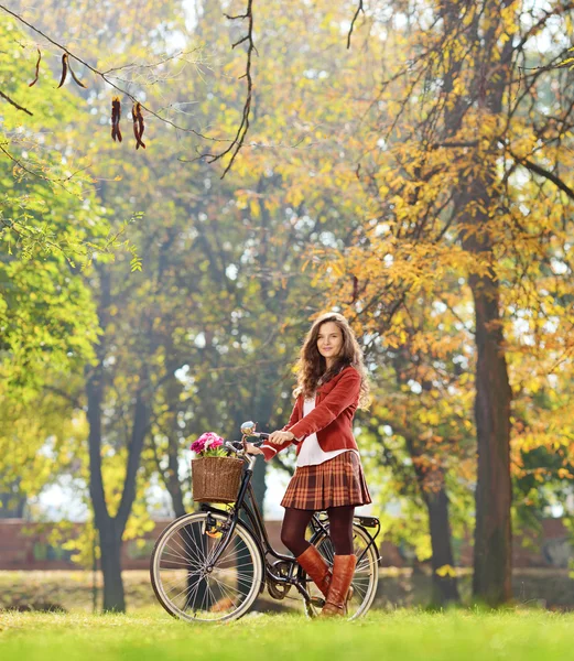 Νεαρή γυναίκα στέκεται με ποδήλατο — Φωτογραφία Αρχείου