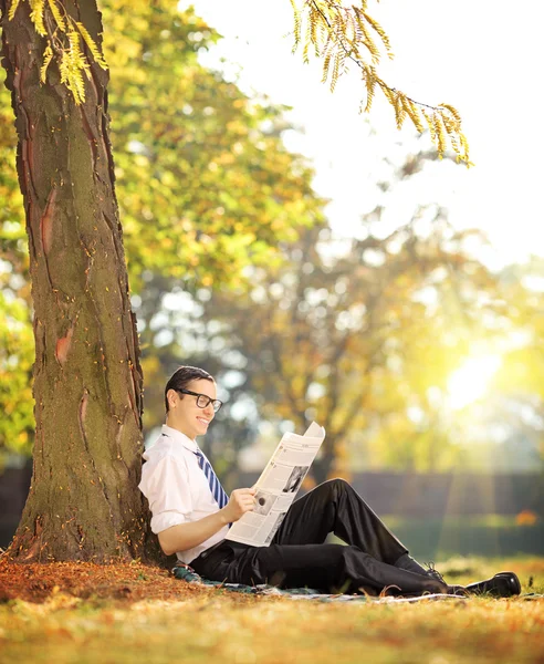 Человек, читающий газету в парке — стоковое фото