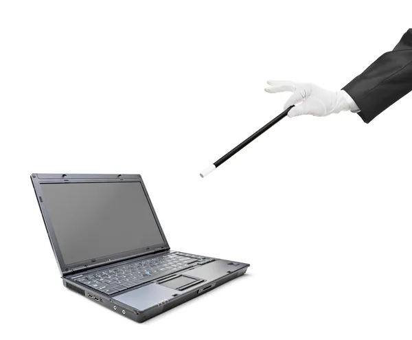 Ein Zauberer hält einen Zauberstab über einen Laptop — Stockfoto