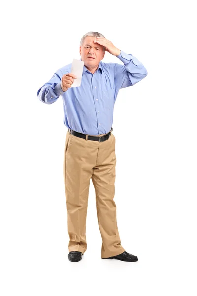 Surprised senior looking at store receipt — Stock Photo, Image