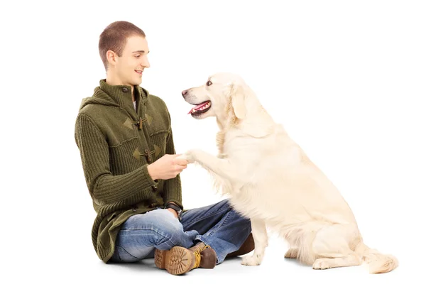 Молодой человек играет с собакой — стоковое фото