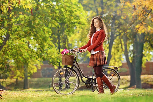 Young female walking with bicycle in park — Stock Photo, Image