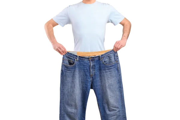 Weight loss male showing old jeans — Stock Photo, Image