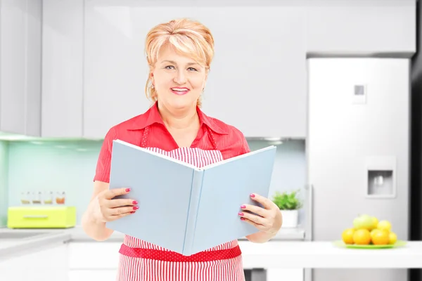 Cooker holding book of recipies — Stock Photo, Image