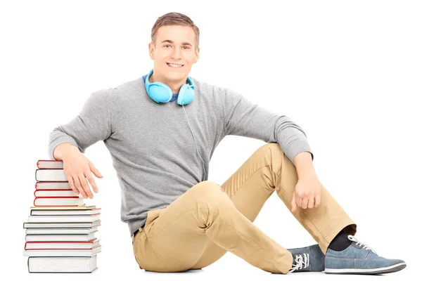 Man with headphones on stack of books — Stock Photo, Image