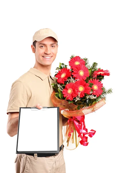 Delivery boy delivering bouquet of flowers and holding a clipboard — Stock Photo, Image