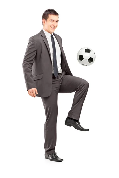 Businessman kicking football — Stock Photo, Image