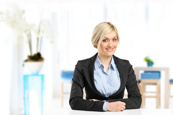 Bionda sorridente donna d'affari seduta alla scrivania — Foto Stock