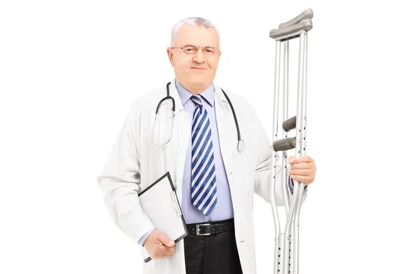 Medical doctor holding crutches — Stock Photo, Image