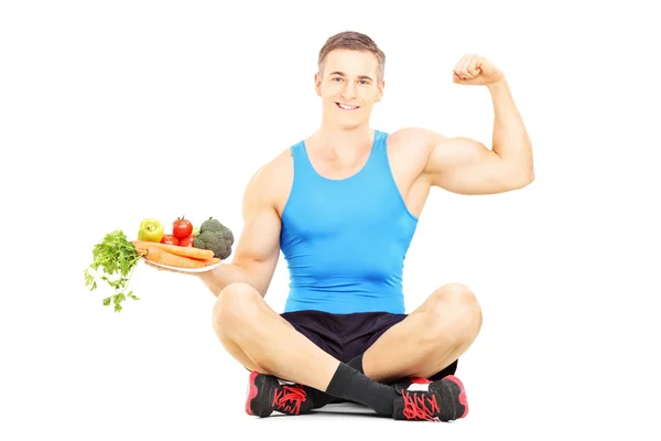Спортсмен держит свежие овощи — стоковое фото