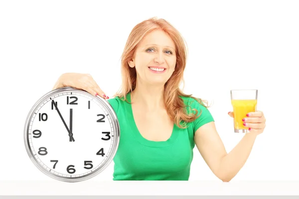 Woman holding wall clock and glass — Stock Photo, Image