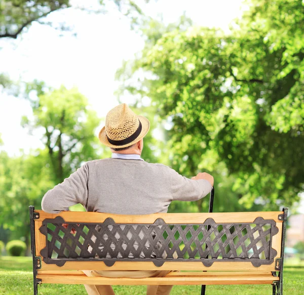 Зрелый мужчина отдыхает на скамейке — стоковое фото