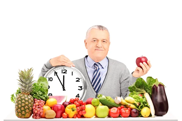 Mature man with apple and clock — Stock Photo, Image