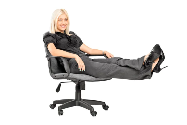 Kvinna sitter på stolen med benen — Stockfoto
