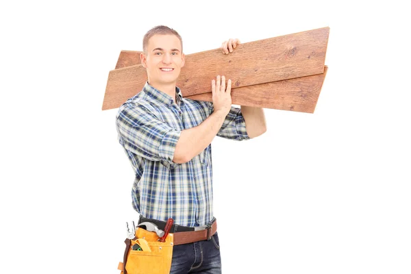 Carpenter carrying planks over shoulder — Stock Photo, Image