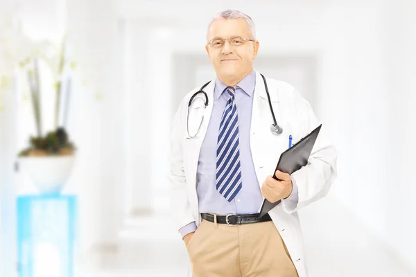 Middle aged doctor holding clipboard — Stock Photo, Image