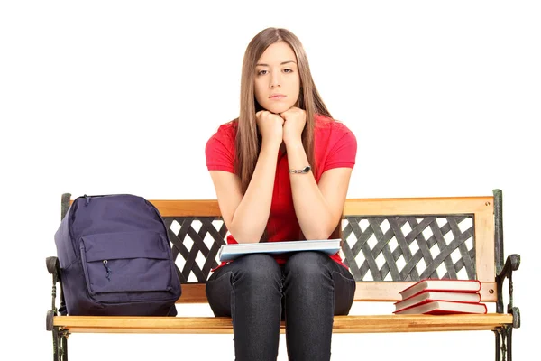 Ongelukkig vrouwelijke student zittend op een houten bankje — Stockfoto