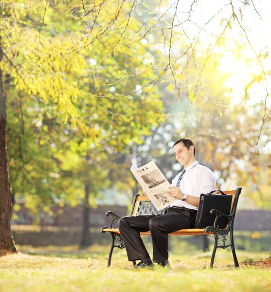 Man reading a newspaper in park — Stock Photo, Image