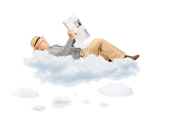 Senior reading newspaper on clouds — Stock Photo, Image