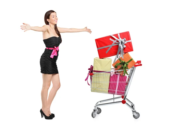 Woman posing next to shopping cart — Stock Photo, Image