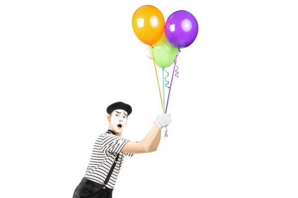 Mime artist holding balloons and flying — Stock Photo, Image