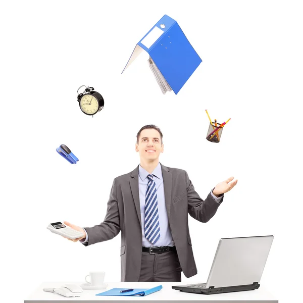 Businessman juggling with office supplies — Stock Photo, Image