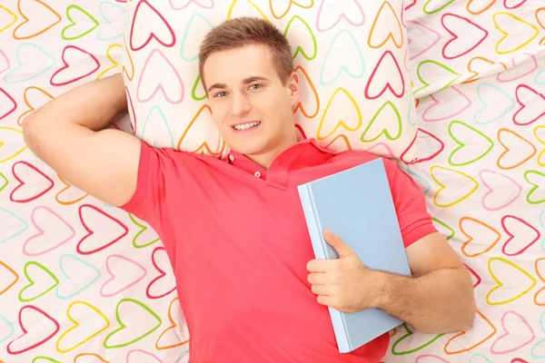 Guy lying on a bed — Stock Photo, Image