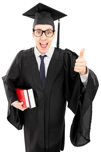 Man in gown holding books and thumb up — Stock Photo, Image