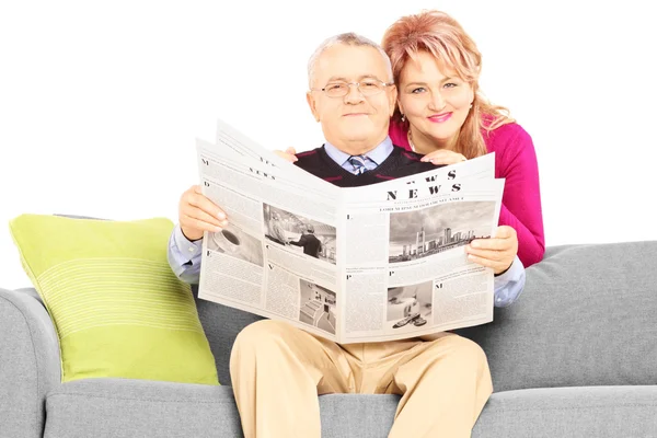 Paar mit Zeitung sitzt auf Couch — Stockfoto