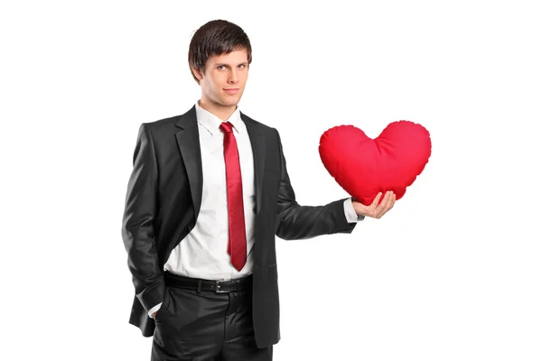 Kalp şeklinde yastık tutan adam — Stok fotoğraf