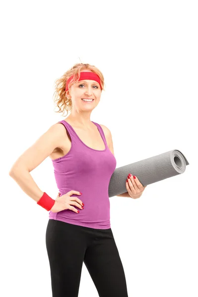 Female athlete holding mat — Stock Photo, Image