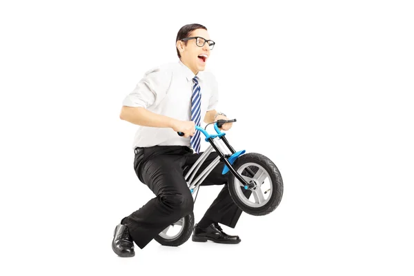 Бизнесмен на маленьком велосипеде — стоковое фото