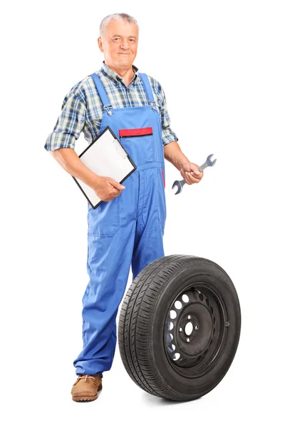 Mechanic holding wrench and clipboard — Stock Photo, Image