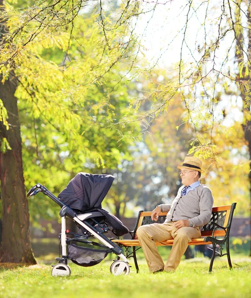 Farfar tittar på brorson i barnvagn — Stockfoto