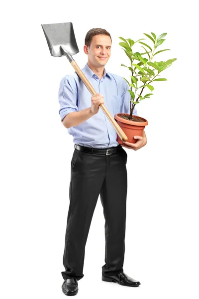 Man holding plant and shovel — Stock Photo, Image