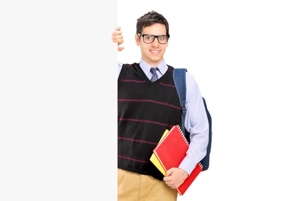 Estudante masculino atrás do painel em branco — Fotografia de Stock