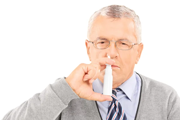 Hombre rociando medicamentos en la nariz — Foto de Stock