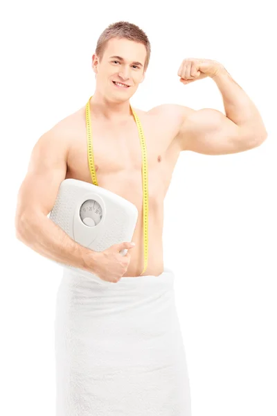 Man in towel holding weight scale — Stock Photo, Image