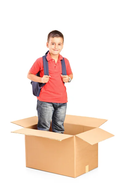 Barn med ryggsäck i cardbox — Stockfoto