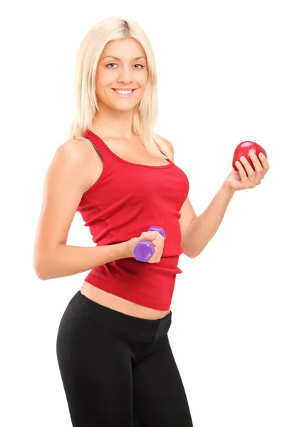 Female holding dumbbell and apple — Stock Photo, Image