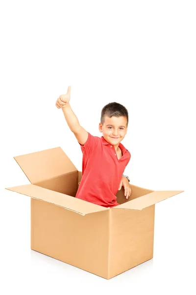Ребенок в коробке показывает большой палец вверх — стоковое фото