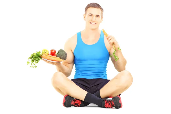 Atleta segurando legumes frescos — Fotografia de Stock