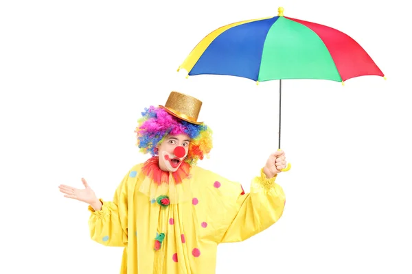 Um palhaço alegre segurando um guarda-chuva colorido — Fotografia de Stock