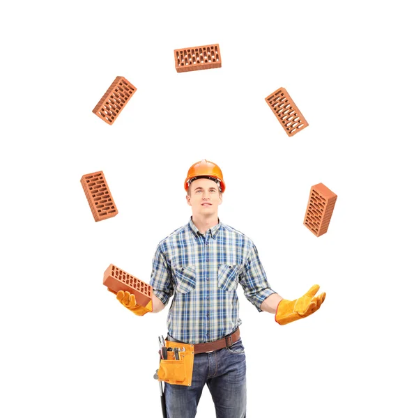 Trabajador de la construcción haciendo malabares con ladrillos — Foto de Stock