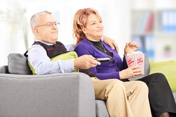 Pareja comiendo palomitas de maíz y viendo televisión — Foto de Stock